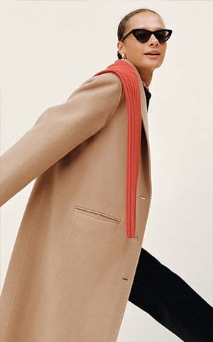 winter fashion trend red scarf with a brown coat and black pants